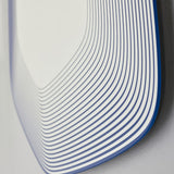 Close-up of the Vibe Blue Line Print Irregular Wall Mirror 80cm, showing concentric blue lines on glass forming a soft five-sided frameless shape.