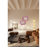 Two Vibe Pink irregular wall mirrors with concentric magenta line prints on frameless glass, displayed on a wall above a sideboard in a living room setting.