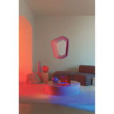Vibe Pink Line Print Irregular Wall Mirror 80cm with magenta concentric line design, shown mounted in a living room above a coffee table and sofa.
