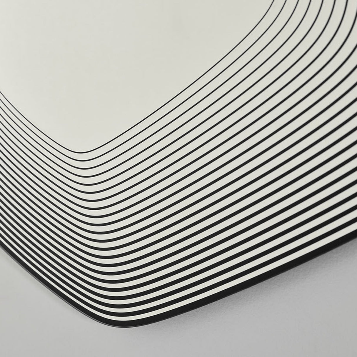 Close-up of Vibe Black Line Print Irregular Wall Mirror 80cm, showing concentric black lines printed on glass curving around the frameless corner.