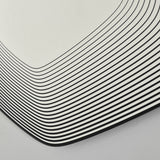 Close-up of Vibe Black Line Print Irregular Wall Mirror 80cm, showing concentric black lines printed on glass curving around the frameless corner.