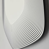 Close-up of the Vibe Black Line Print Irregular Wall Mirror 80cm, showing concentric black lines printed on frameless glass curving around the rounded edge.