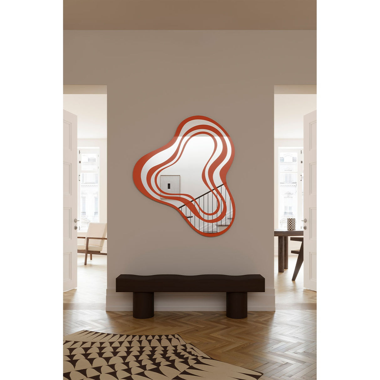 Nimbus Orange Banded Glass Wall Mirror 123cm with an irregular, cloud-like outline in orange and silvered bands, shown mounted above a dark bench in a hallway.