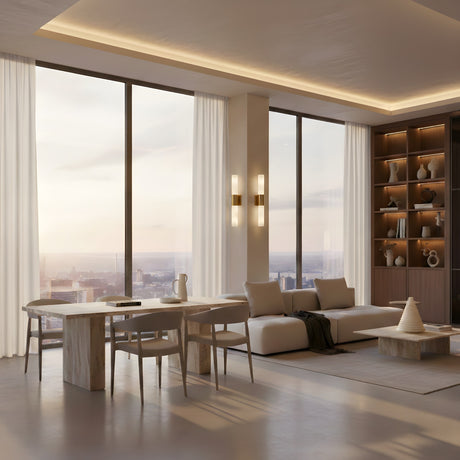 A modern living and dining area with floor-to-ceiling windows, neutral furnishings, a marble dining table, white sofa, textured rug, built-in shelves with decor, city sunset views, and Fiora LED Alabaster Wall Lights in brushed brass & soft white.
