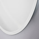 Close-up of the Pure Bevelled Edge Organic Wall Mirror 78cm, showing the frameless irregular oval outline and wide pale bevel against a light grey wall.