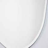 Close-up of the Pure Bevelled Edge Organic Wall Mirror 78cm, showing the frameless irregular oval outline and wide bevelled edge against a plain wall.
