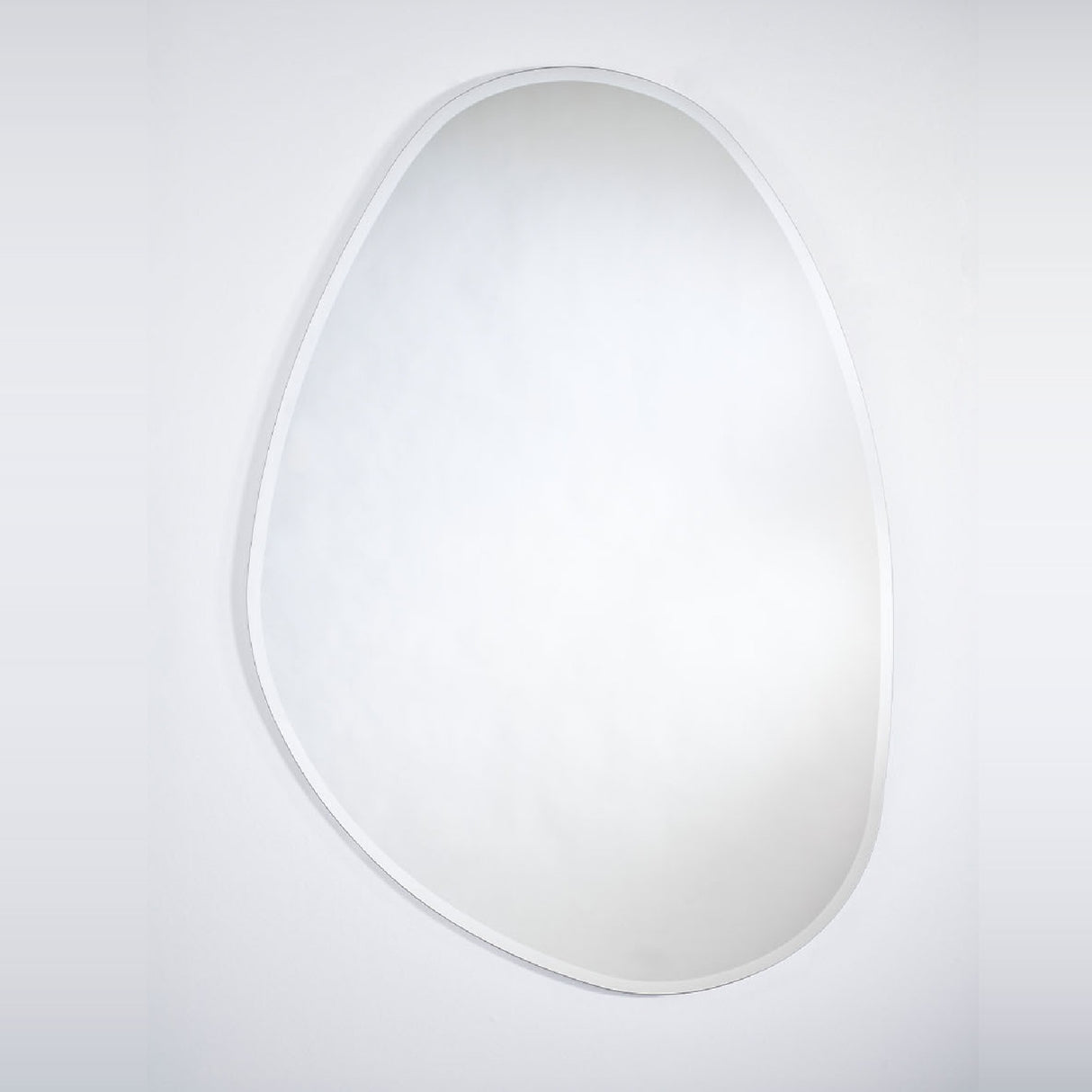 Frameless wall mirror cut to a soft organic outline, with a bevel two centimetres wide following the whole contour.