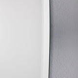 Close-up of the bevelled edge against a textured wall, the ground angle catching the light along the contour.