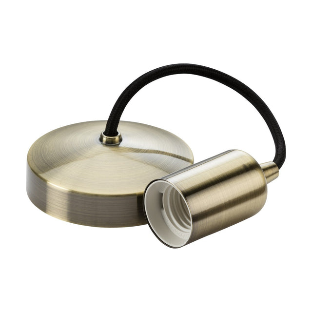 Introducing the 6" ES Contemporary Pendant Set in Antique Brass, which showcases a metallic pendant light fixture. This design includes a round ceiling mount and a cylindrical socket compatible with an E27 lamp base, all elegantly connected by a black fabric-covered cord.