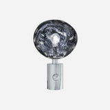 The Ex-Display Lava Table Lamp - Silver is a contemporary lighting piece with a shiny, cylindrical chrome base and a large, uniquely shaped clear glass bulb that showcases the lightbulb within—all set against a plain white background.