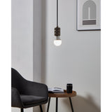 Pendant light fitted with a 3 Step Dimmable LED GLS bulb, opal pear-shaped dome on a bronze lamp holder, glowing warm white above a side table in a living room setting.