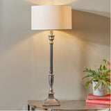 Canterbury Antique Silver Aluminium Table Lamp with fluted column base and cream drum shade, styled on a console table beside books and a potted plant.