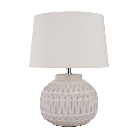 Anneli table lamp with a round ceramic base in warm white featuring an Aztec textured pattern, topped with a white tapered fabric shade, on a plain background.