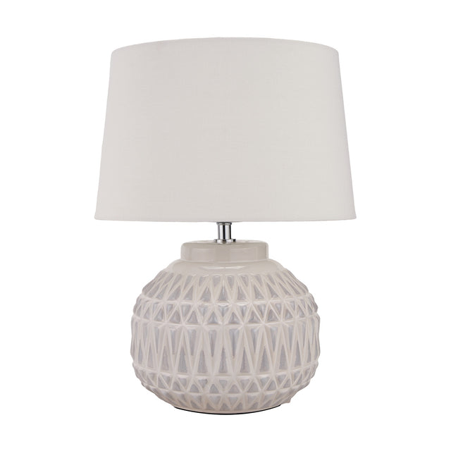 Anneli table lamp with a round ceramic base in warm white featuring an Aztec textured pattern, topped with a white tapered fabric shade, on a plain background.