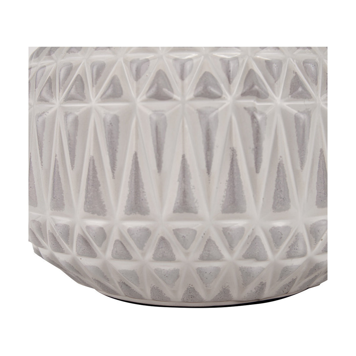Close-up of the Anneli table lamp base showing warm white glazed ceramic with a raised geometric Aztec-style triangle texture, on a plain background.
