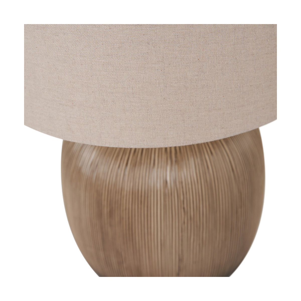 Close-up of the Greta table lamp's rounded, ridged brown ceramic base beneath a neutral linen drum shade, shown on a plain white background.
