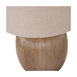 Close-up of the Greta table lamp's rounded, ridged brown ceramic base beneath a neutral linen drum shade, shown on a plain white background.