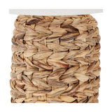 Close-up of the Zadi Table Lamp's base showing natural water hyacinth plaited in a herringbone weave, with a pale linen shade edge visible above.