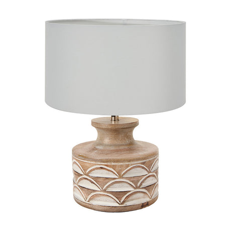 Kingsbury table lamp with a white wash carved wood base featuring a scalloped pattern and a drum-shaped ivory cotton shade, shown on a plain white background.