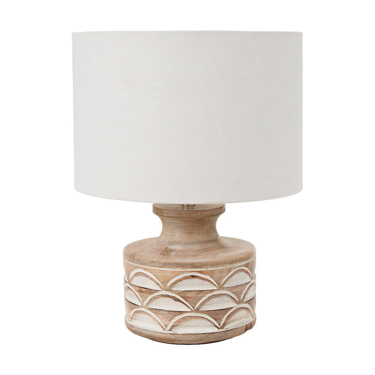 Kingsbury table lamp with a white wash carved wood base featuring a scalloped pattern, paired with a white drum shade, shown on a plain white background.