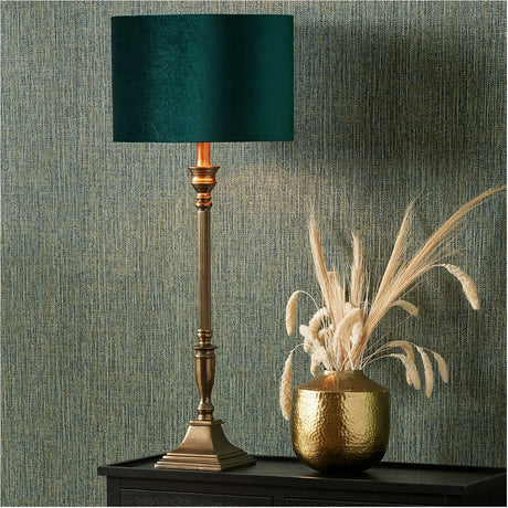 Canterbury Antique Brass Table Lamp Base with turned column stem and stepped square foot, styled with a teal shade on a dark sideboard beside a hammered gold vase.