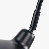 Close-up of the Toulon Black Iron Task Table Lamp showing the matte black metal joint where the flexible arm connects to the rounded base, on a plain white background.