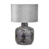 Vulcan table lamp with textured volcanic-effect grey stoneware base and rounded silver-grey fabric drum shade, shown on a plain white background.