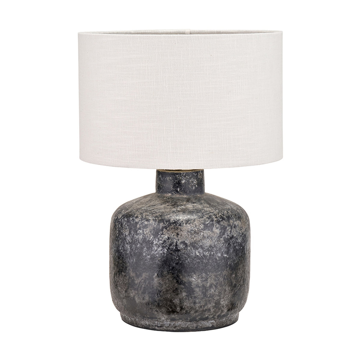 Vulcan table lamp with textured volcanic-effect grey stoneware base and white drum shade, shown on a plain white background.