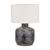 Vulcan table lamp with textured volcanic-effect grey stoneware base and white drum shade, shown on a plain white background.