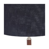Close-up of the Gianni Table Lamp's navy linen drum shade with visible woven texture, joined to a wood-effect stem by a brushed silver collar.