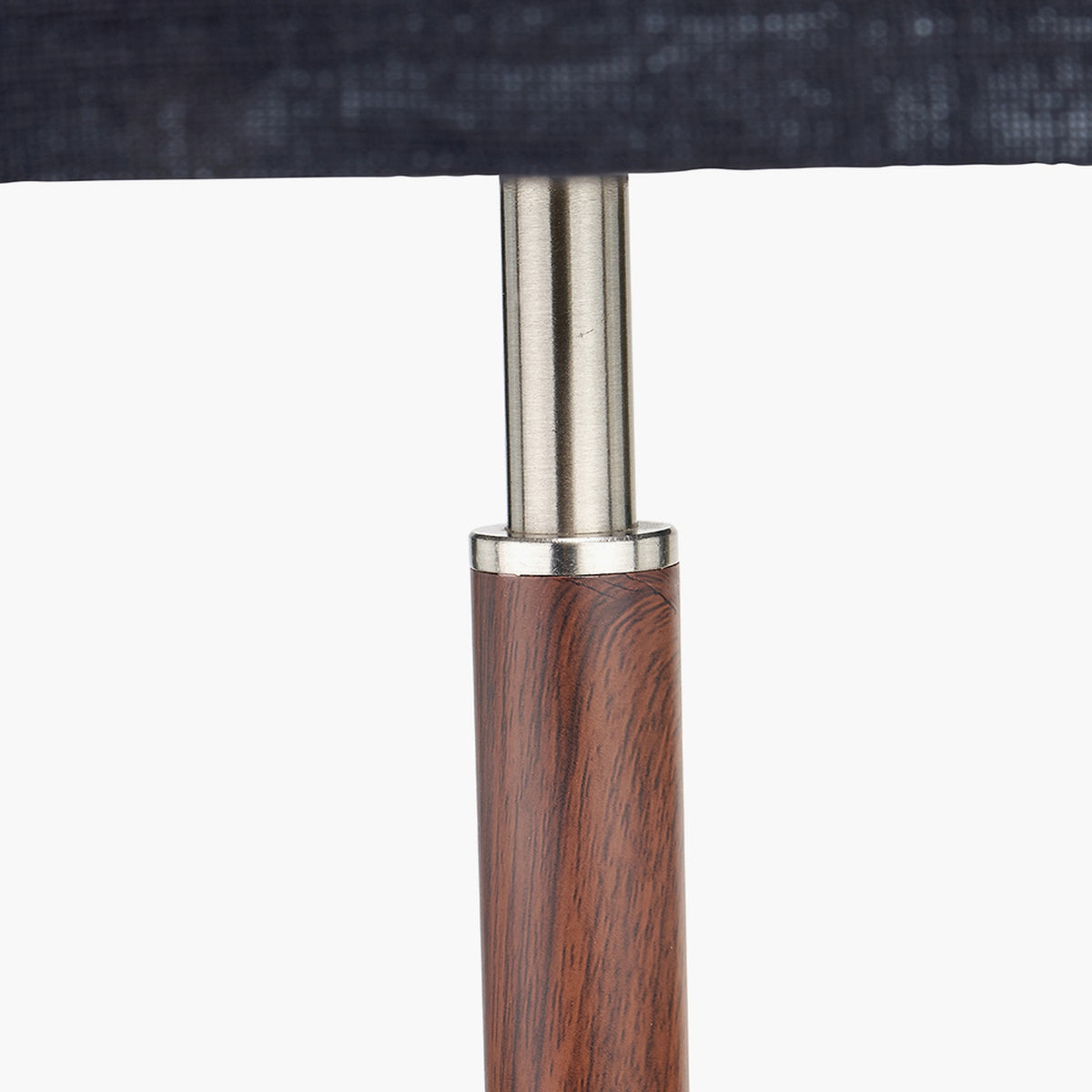 Gianni Table Lamp close-up showing the brushed silver neck joint above a wood-effect base, paired with a dark grey linen shade, on a plain background.