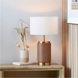 Carrara Wood Effect Ceramic Table Lamp, 48cm, with a wood-effect cylindrical ceramic base, brass fittings, and white fabric drum shade, styled on a wooden sideboard beside a vase of dried grasses.