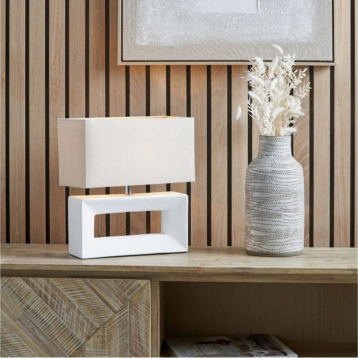 Block White Ceramic Rectangular Table Lamp with linen shade on a wooden sideboard, styled beside a patterned grey vase and framed wall art.