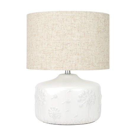 Flora White Small Floral Ceramic Table Lamp, 33cm, with a raised dandelion motif base and a natural linen drum shade, shown on a plain white background.