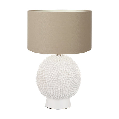 Wrenley table lamp with a round, textured white ceramic sea urchin-style base and a taupe drum fabric shade, shown on a plain white background.
