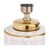 Close-up of the Thea ceramic table lamp base's gold neck fitting with brass lamp holder, sitting above a white body patterned with lilac floral motifs and a gold rim band.