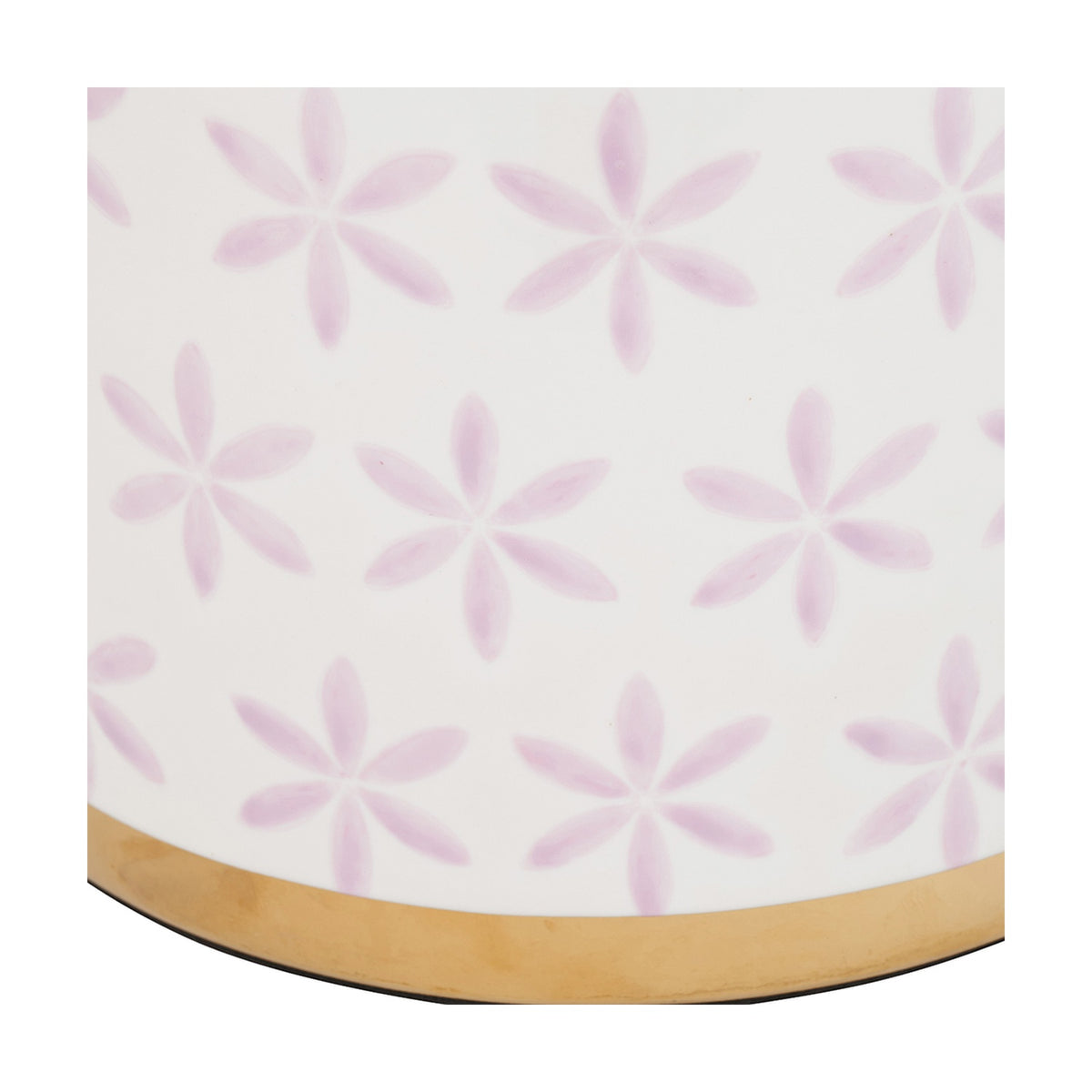 Close-up of the Thea ceramic table lamp base showing lilac six-petal flower motifs on a white ground above a gold-finished lower band.