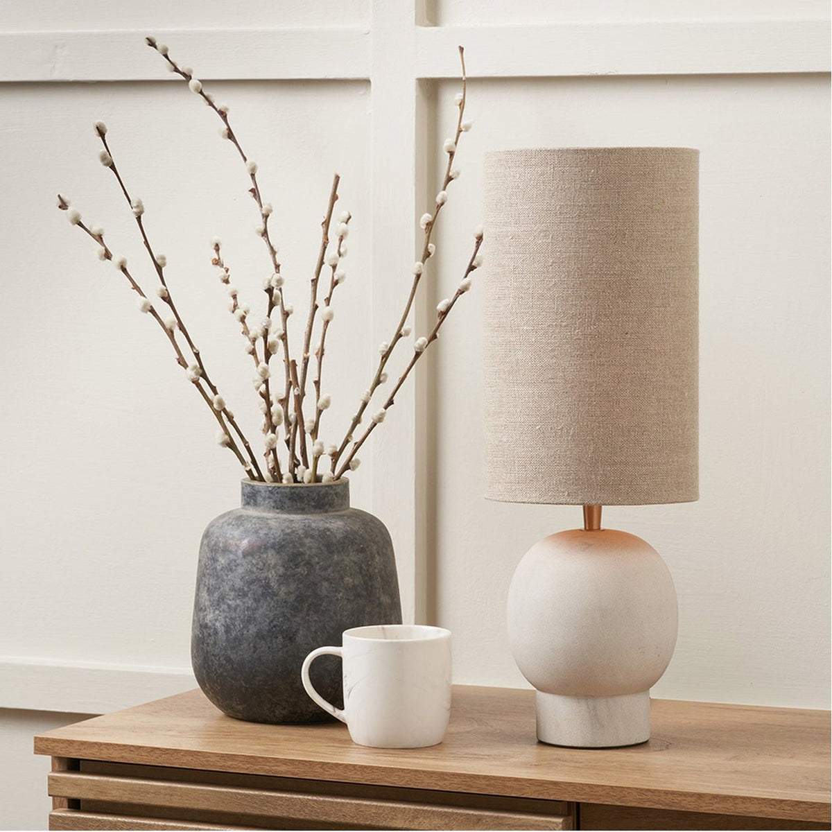 Althea Sandstone Table Lamp, 48cm, with round stone base and natural linen drum shade, styled on a wooden sideboard beside a stoneware vase and marble mug.