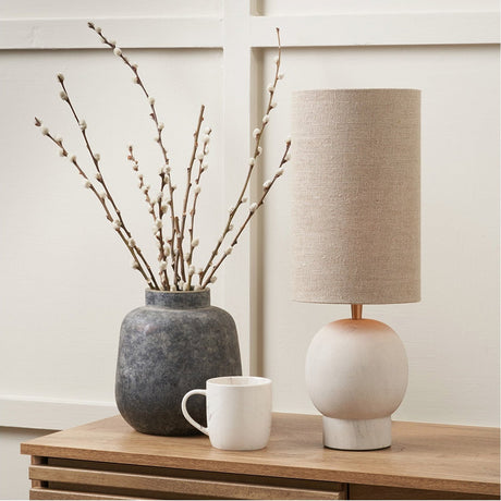 Althea Sandstone Table Lamp, 48cm, with round stone base and natural linen drum shade, styled on a wooden sideboard beside a stoneware vase and marble mug.