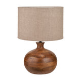 Kiah table lamp with a round, bulbous oiled mango wood base in brown tones and a natural linen drum shade, shown on a plain white background.