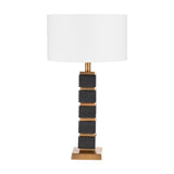 Maximo table lamp with white drum shade on a stacked cube base in matt black and antique brass finish, shown on a plain white background.