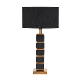 Maximo table lamp with stacked matt black cube design and antique brass banding on a square brass base, paired with a black drum shade, shown on a white background.
