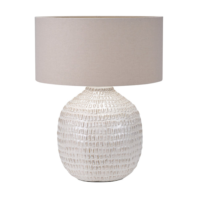 Signe table lamp with a rounded, textured warm white ceramic base and a plain drum linen shade in taupe, shown on a white background.
