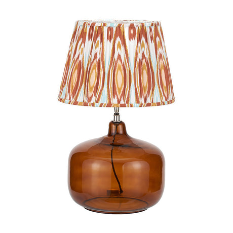 Corby Amber Glass Table Lamp, 61cm, with a rounded amber glass base, nickel fitting, and pleated cinnamon ikat-print fabric shade, on a plain white background.