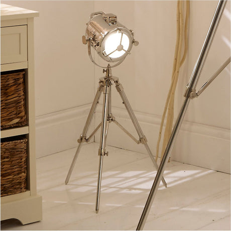 Marine Nickel Silver Searchlight Table Lamp, 67cm, on tripod stand with round spotlight-style shade, shown in a living room beside cream furniture and woven baskets.