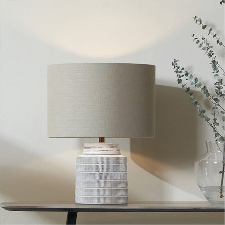 Paihia White Wash Wood Textured Short Table Lamp Base, 29cm, with grey drum shade, styled on a console table beside a glass vase and eucalyptus stems.