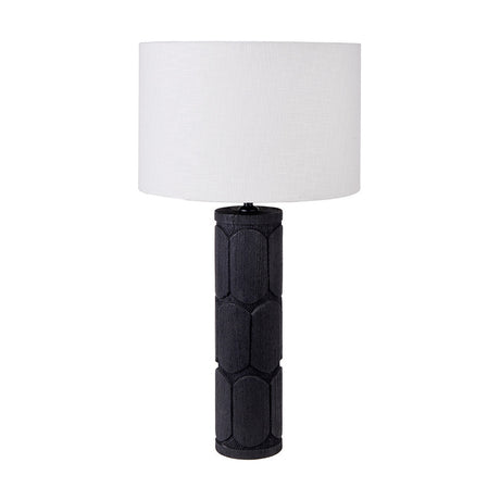 Aurelia Embossed Black Wood Tall Table Lamp with a cylindrical carved wood base and white drum self shade, shown on a plain white background.