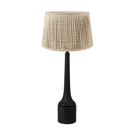Marin table lamp with a tall black wood neck and round base, topped with a pleated taupe chevron fabric shade, shown on a plain white background.