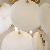 Close-up of the Solyra 6 Light 2 Tier Petal Alabaster Chandelier in Soft White, featuring large round alabaster discs and gold accents, partially concealing multiple bright bulbs behind them.