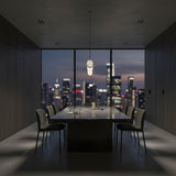 A modern conference room with a long table, six chairs, and a laptop overlooks the city skyline at dusk. Above the table hangs the Zareon LED Small Linear Alabaster Suspension Light – Soft White, illuminating the minimalist interior.